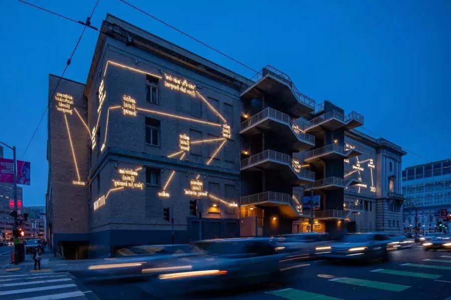 贝博体彩app的一座建筑被艺术家约瑟夫·科苏斯(Joseph Kosuth)的发光作品照亮