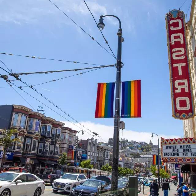 Das Castro-Viertel von San Francisco mit dem Castro-Theater-Schild und Regenbogenfahnen im Vordergrund.
